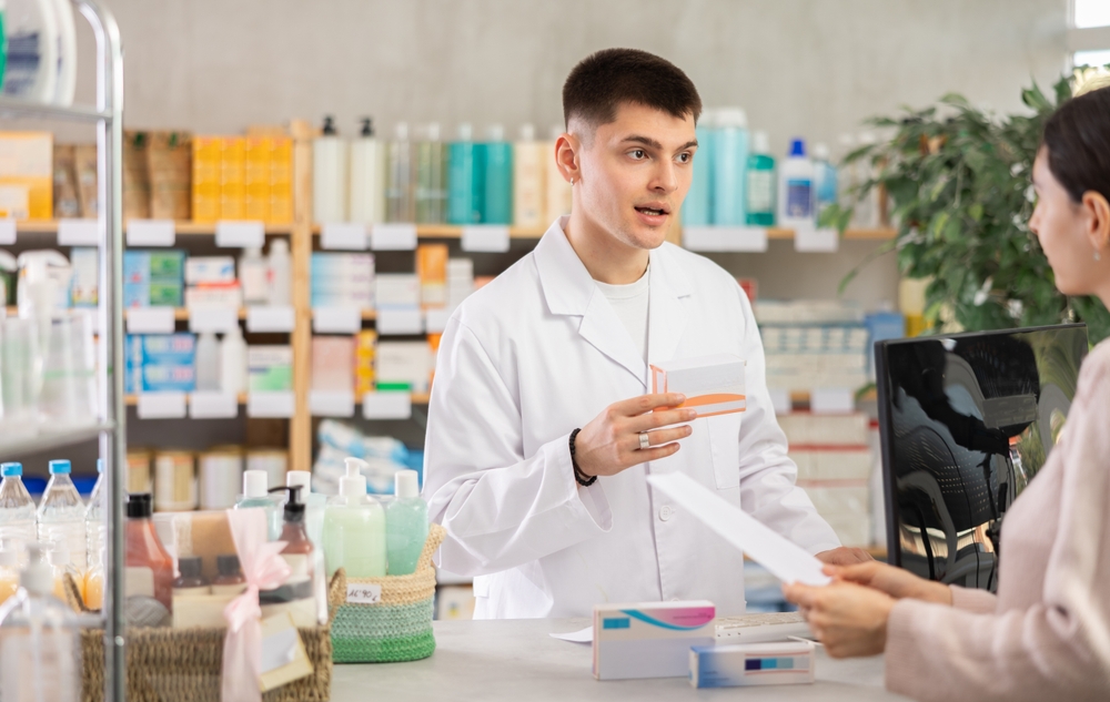 Pharmacist checking pharmacy label requirements against a printed bottle label from AllLabels